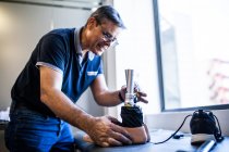 Инженер-протезист рассматривает протез пациента и улучшает материал в его мастерской — стоковое фото