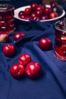 Bevanda rossa vicino a frutta fresca su panno blu — Foto stock