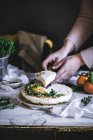 Крупним планом жіночих рук беручи скибочку вершковий пиріг Мандарин на білій тканині — стокове фото