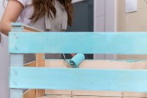 Gros plan de femme douleur boîte en bois de couleur bleue avec rouleau — Photo de stock