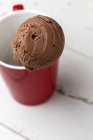 Chocolate ice cream scoop in red cup, close-up — Stock Photo