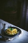 De acima mencionado apetitoso macarrão com legumes manjericão em tigela preta na mesa servida — Fotografia de Stock
