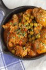 From above hot skillet with cooked delicious meatballs and green peas on white tablecloth — Stock Photo