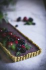 Savoureux gâteau rectangulaire décoré avec des baies d'été sur table blanche — Photo de stock