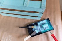 Caja de madera recién pintada y herramientas en la mesa - foto de stock