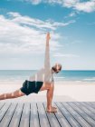 Дорослий підходить бородатий чоловік робить йогу на дерев'яному пірсі на березі моря, дивлячись — стокове фото