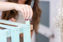 Primer plano de la mano femenina dolor caja de madera en color azul con cepillo - foto de stock