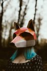 Anonyme femelle en masque de renard en papier marchant dans une mystérieuse forêt d'automne par temps couvert. Concept de protection de l'habitat faunique — Photo de stock