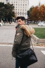 Модний молодий чоловік розмовляє по мобільному телефону під час прогулянки по дорозі в осінній день — стокове фото