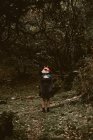 Mulher anônima em máscara de raposa de papel andando na misteriosa floresta de outono em tempo nublado. Conceito de proteção do habitat da vida selvagem — Fotografia de Stock