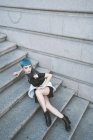 Молода жінка з коротким блакитним волоссям в модному неформальному одязі і позує на вулиці кроки — стокове фото