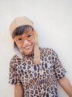 Smiling cute kid in decorative glasses and leopard costume looking at camera — Stock Photo