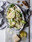 From above dish with delicious salad made of apples, parmesan cheese, walnuts, celery and oil on table — Stock Photo