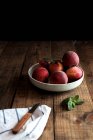 Вкусные спелые персики в тарелке на столе — стоковое фото