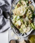 De dessus plat avec délicieuse salade de pommes, fromage parmesan, noix, céleri et huile sur la table — Photo de stock