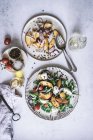 De cima pratos com saladas gourmet feitas de pêssegos, cebola vermelha, queijo, óleo e pimenta preta na mesa — Fotografia de Stock