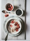 Serviert Haferflocken in Schüssel mit Erdbeeren und Chiasamen auf weißem Hintergrund — Stockfoto