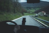 Vista de dentro do carro de estrada vazia de área rural em tempo nublado — Fotografia de Stock