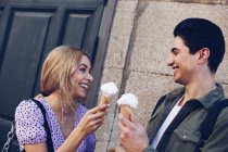 Jovem alegre atraente mulher e namorado comendo sorvete ao ar livre — Fotografia de Stock