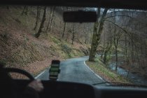 Вид изнутри автомобиля на пустую сельскую дорогу в пасмурную погоду — стоковое фото