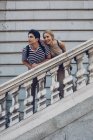 Casal atraente admirando vista enquanto estava em pé sobre escadas antigas do edifício histórico — Fotografia de Stock