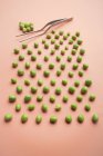 Set of fresh green peas on salmon background — Stock Photo