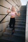 Молода блондинка біла жінка згинає м'язи зі спортивним одягом на відкритому повітрі — стокове фото