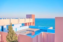 Incredibile piscina con acqua dolce che riflette il cielo sul tetto di edificio a forma di in luminosa giornata di sole — Foto stock