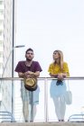 Young stylish young couple standing on bridge in city — Stock Photo