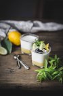 Bicchieri con yogurt fatto in casa e cagliata di limone sulla superficie di legno — Foto stock