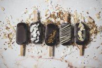 Асорті шоколадного морозива паприки, покриті начинками на мармуровій поверхні — стокове фото