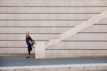 Молодая блондинка, растянувшаяся на лестнице после бега — стоковое фото