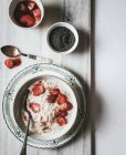 Flocons d'avoine servis dans un bol avec des fraises et des graines de chia en fond blanc — Photo de stock