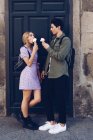 Fröhliche junge attraktive Frau und Freund essen Eis im Freien — Stockfoto