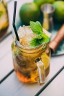 Mojito-Cocktail mit Limette, Minze, Rum, Soda und Eis im Einmachglas auf dem Tisch mit Zutaten — Stockfoto