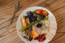 Von oben Teller mit reifen saftigen Tomaten Salatgemüse knusprige Brote auf Holztisch — Stockfoto