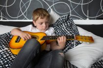 Jovem loira menino tocando guitarra brinquedo — Fotografia de Stock
