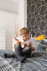 Jeune garçon blonde jouant de la guitare jouet — Photo de stock
