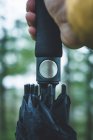 Closeup crop man hand with handle of umbrella pressing button for open umbrella on blurred background — Stock Photo