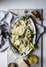 Von oben mit köstlichem Salat aus Äpfeln, Parmesan, Walnüssen, Sellerie und Öl auf dem Tisch — Stockfoto