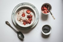 Served oatmeal in bowl with strawberries and chia seeds in white background — Stock Photo