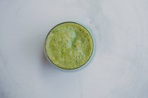 De cima bolha espumante saboroso smoothie verde perfumado em vidro na mesa de madeira — Fotografia de Stock