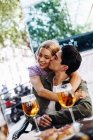 Allegro giovane attraente coppia baciare mentre godendo bevande rinfrescanti — Foto stock