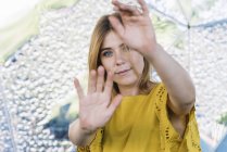 Giovane donna dagli occhi azzurri tirando le mani alla macchina fotografica su sfondo metallico — Foto stock