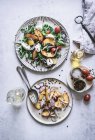 Von oben Teller mit Gourmet-Salaten aus Pfirsichen, roten Zwiebeln, Käse, Öl und schwarzem Pfeffer auf dem Tisch — Stockfoto