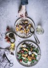 Зверху чоловік тримає тарілку з літнім салатом з фруктів, овочів та спецій — стокове фото