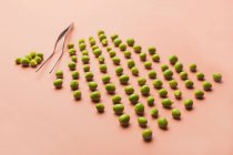 Set of peas in a rows on salmon background — Stock Photo