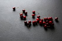 Glänzend reife rote Kirschen auf schwarzem Hintergrund — Stockfoto