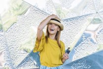 Молода стильна весела жінка позує в солом'яному капелюсі на металевому фоні — стокове фото