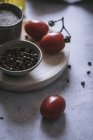 Close-up of pepper and salt with fresh tomatoes on wooden board — Stock Photo